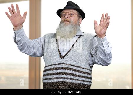 Überraschte alten Mann in Brillen mit transparenten virtuellen Bildschirm. Leitender intelligenter Mann, der mit transparenter virtueller Schnittstelle arbeitet. Stockfoto