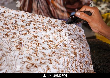 Die Technik der Herstellung von Batik durch Schreiben mit einem Eckwerkzeug. Das Galoppieren besteht aus Nyamplung, Gurkuk, Gagang oder Griffen aus Kupfer, Bambus und Wachs. Stockfoto