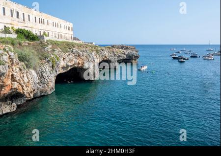 Santa maria di Leuca, Apulien, Italien. Atemberaubende Aussicht auf die natürlichen Höhlen an der Küste: Badegäste schwimmen im kristallklaren Wasser, um sie aus nächster Nähe zu sehen. Stockfoto