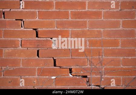 Rote Backsteinmauer mit großem krachenden und zerbröckelnden Mörtel Stockfoto