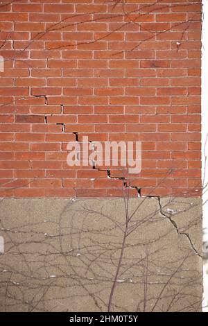 Rote Ziegelmauer und Fundament mit großem, zerbröckelnden Mörtel Stockfoto