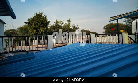 Das Dach des blauen Blechhauses. Blaues Dach auf der Terrasse eines Betonhauses, um es vor den Elementen zu schützen. Stockfoto