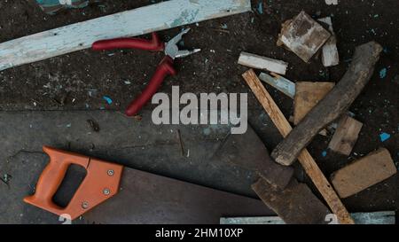 Alte Werkzeuge liegen auf dem Boden. Bauwerkzeuge für Hausreparatur und Bau. Säge, Hammer und Axt. Rostige Vintage-Werkzeuge. Vintage, Retro, Rost Stockfoto