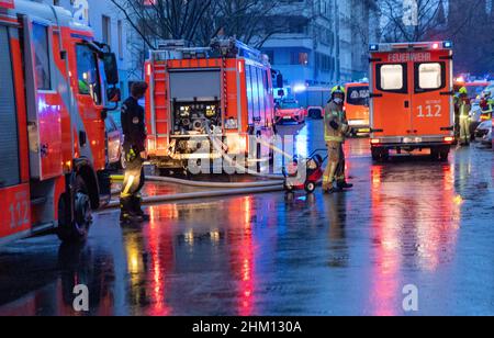 Berlin, Deutschland. 06th. Februar 2022. Rettungsfahrzeuge der Feuerwehr stehen auf der Straße in einem Haus für Obdachlose. Im Untergeschoss des mehrstöckigen Gebäudes war ein Feuer ausgebrochen. Nach Angaben eines Sprechers ist es der Feuerwehr gelungen, den Brand relativ schnell zu löschen. Quelle: Carsten Koall/dpa/Alamy Live News Stockfoto