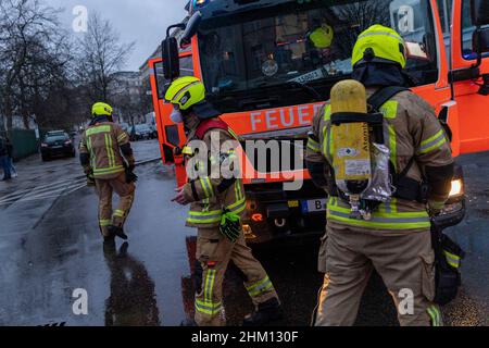 Berlin, Deutschland. 06th. Februar 2022. Rettungsfahrzeuge der Feuerwehr stehen auf der Straße in einem Haus für Obdachlose. Im Untergeschoss des mehrstöckigen Gebäudes war ein Feuer ausgebrochen. Nach Angaben eines Sprechers ist es der Feuerwehr gelungen, den Brand relativ schnell zu löschen. Quelle: Carsten Koall/dpa/Alamy Live News Stockfoto