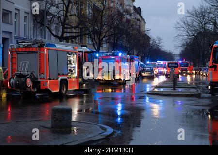 Berlin, Deutschland. 06th. Februar 2022. Rettungsfahrzeuge der Feuerwehr stehen auf der Straße in einem Haus für Obdachlose. Im Untergeschoss des mehrstöckigen Gebäudes war ein Feuer ausgebrochen. Nach Angaben eines Sprechers ist es der Feuerwehr gelungen, den Brand relativ schnell zu löschen. Quelle: Carsten Koall/dpa/Alamy Live News Stockfoto