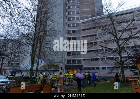 Berlin, Deutschland. 06th. Februar 2022. Feuerwehrleute stehen vor einem Heim für Obdachlose. Im Untergeschoss des mehrstöckigen Gebäudes war ein Feuer ausgebrochen. Nach Angaben eines Sprechers ist es der Feuerwehr gelungen, den Brand relativ schnell zu löschen. Quelle: Carsten Koall/dpa/Alamy Live News Stockfoto
