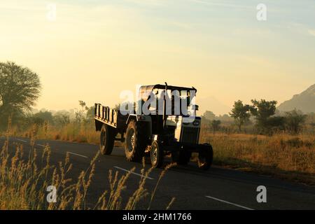 Bauern in einem Traktor, die nach der Arbeit in einem ländlichen Dorf gehen. Javadhu Hills, Tamil Nadu. Indien. Stockfoto