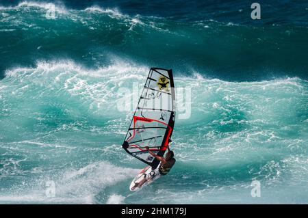 Windsurfer segeln in großen Wellen am Ho'okipa Beach, Maui, Hawaii, USA. Stockfoto