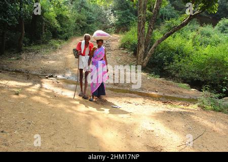 Eine alte Frau und ein Mann, die in einem ländlichen Dorf nach Hause gehen. Javadhu Hills, Tamil Nadu. Indien. Stockfoto