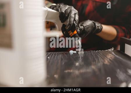 Nahaufnahme des Tätowierers, der Werkzeuge und Tinte vor der Arbeit vorbereitet Stockfoto