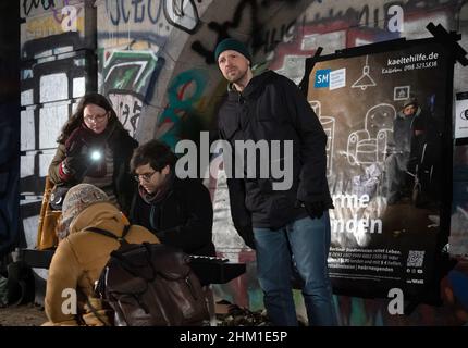 Berlin, Deutschland. 06th. Februar 2022. Bariton Johannes Held (r) und der Pianist Jean-Sélim Abdelmoula führen unter der Brücke in der Bornholmer Straße „Schuberts Winterreise“ zugunsten der Kalthilfe der Berliner Stadtmission auf. Mit dem Liederzyklus der Musikgeschichte machen sie auf die Situation der Obdachlosen in der Stadt aufmerksam und sammeln Spenden für den Berliner Kaltbus. Quelle: Paul Zinken/dpa/Alamy Live News Stockfoto