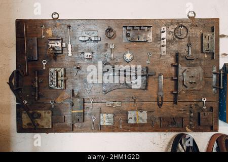 Alte handgefertigte Schlüssel und Schlösser auf einem Holztisch. Stockfoto