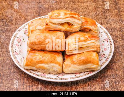 Hausgemachte Kartoffelpasteten in einem Gericht isoliert auf dunklem Holzhintergrund Draufsicht Stockfoto