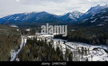 Luftaufnahme des Bull River Valley und des State Highway 56 und der Cabinet Mountains im Winter. (Foto von Randy Beacham) Stockfoto