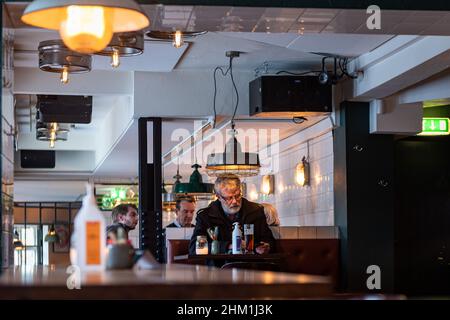 Ein einzelner Mann isst und trinkt in einem Pub in Kopenhagen Dänemark Stockfoto