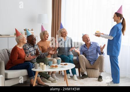 Aufgeregt ältere Menschen mit Geburtstagsfeier im Pflegeheim, Panorama Stockfoto