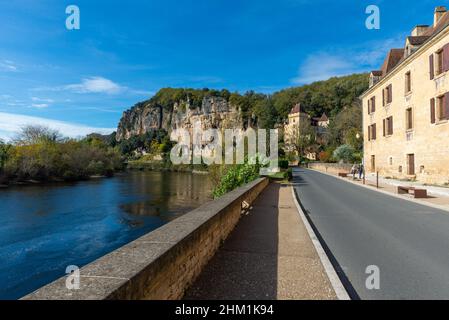 La Roque-Gageac, Frankreich - 31. Oktober 2021: Einige Touristen aus der Ferne gesehen, die die Hauptstraße von La Roque-Gageac mit dem Fluss Dordogne auf einer Straße hinaufgehen Stockfoto