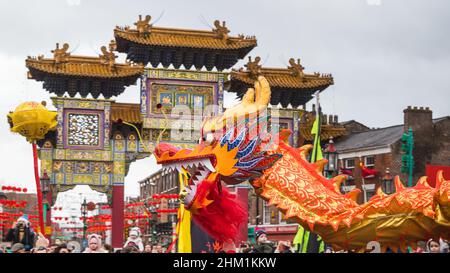 Dragon Dance vor dem Torbogen bei den Feierlichkeiten zum chinesischen Neujahr im Chinatown-Viertel von Liverpool im Februar 2022. Stockfoto