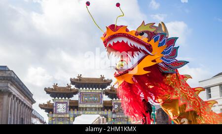 Chinesischer Drache unter einem strahlenden Himmel, der während der Feierlichkeiten zum chinesischen Neujahr in Liverpools Chinatown im Februar 2022 gesehen wurde. Stockfoto