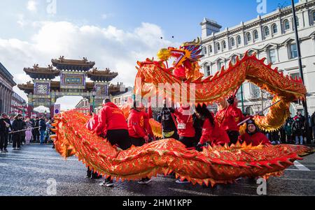 Der Drache rollt während des Drachentanzes vor dem Paifang während der chinesischen Neujahrsfeier in Liverpools Chinatown-Viertel in Februar Stockfoto