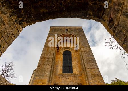 Die befestigte Kirche von Coly-Saint-Armand in Perigord, Frankreich, wurde an einem teilweise sonnigen Herbstnachmittag ohne Menschen aufgenommen. Stockfoto