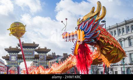 Drache jagt die Perle während der chinesischen Neujahrsfeier im Liverpools Chinatown-Viertel im Februar 2022. Stockfoto