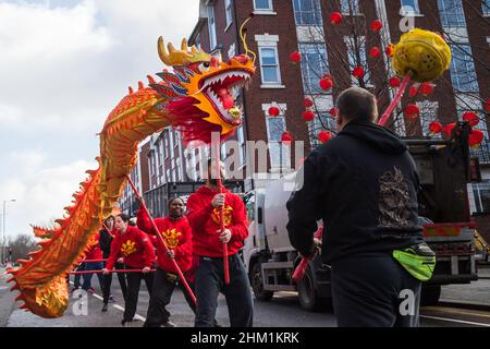 Dragon Dance durch die roten Laternen, die während der chinesischen Neujahrsfeiern im Februar 2022 in Liverpools Chinatown abgebildet wurden. Stockfoto