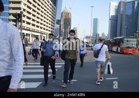 Fußgänger gehen mit Gesichtsmasken, um die Ausbreitung von COVID 19 in Dubai, Vereinigte Arabische Emirate, zu schützen und zu verhindern - 2. Februar 2022. Stockfoto
