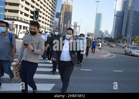 Fußgänger gehen mit Gesichtsmasken, um die Ausbreitung von COVID 19 in Dubai, Vereinigte Arabische Emirate, zu schützen und zu verhindern - 2. Februar 2022. Stockfoto