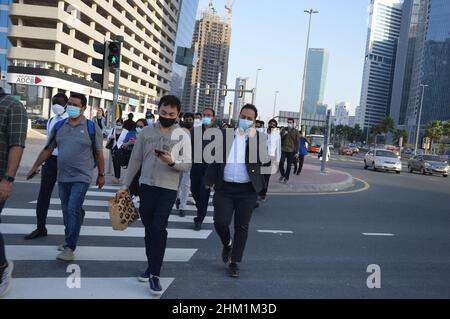 Fußgänger gehen mit Gesichtsmasken, um die Ausbreitung von COVID 19 in Dubai, Vereinigte Arabische Emirate, zu schützen und zu verhindern - 2. Februar 2022. Stockfoto