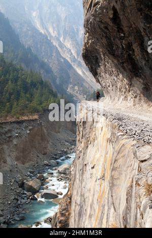 Mann auf dem Weg, Felsenstraße in rund Annapurna Circuit Trekking Trail, Nepal Stockfoto