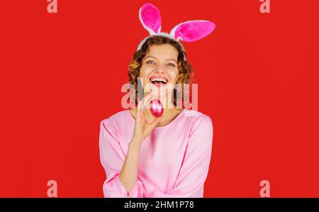 Osterferien. Eiersuche. Glückliche Frau in Hasenohren mit rosa Ei. Kaninchenmädchen. Frühling. Stockfoto