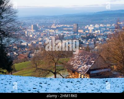 Blick über ein altes Bauernhaus in Richtung Zug, Schweiz, an einem sonnigen Winternachmittag Stockfoto