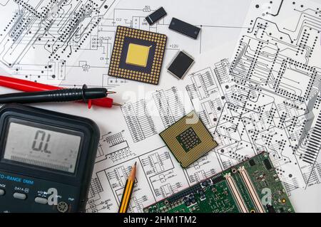 Platine, Bleistift, Prozessoren und Multimeter auf dem Hintergrund des Schaltplans und einer Fotomask. Konzept zur Entwicklung und Gestaltung von Stockfoto