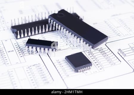 Elektronikkomponenten auf dem Hintergrund des Schaltplans. Konzept für die Entwicklung und Konstruktion von elektronischen Geräten. Stockfoto