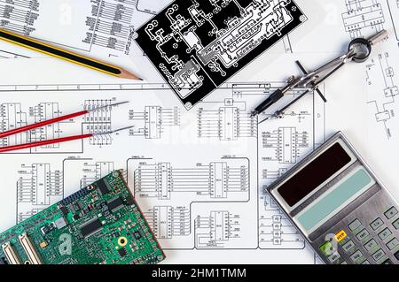 Elektronikkarte, Rechner, Pinzette und Fotomasken auf dem Hintergrund des Schaltplans. Konzept für Entwicklung und Design von elektronischen Entw Stockfoto