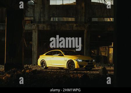 Gelber BMW M4 auf einer Baustelle geparkt Stockfoto