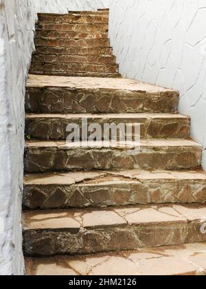 Im Hintergrund führt eine alte Treppe aus Naturstein nach oben Stockfoto