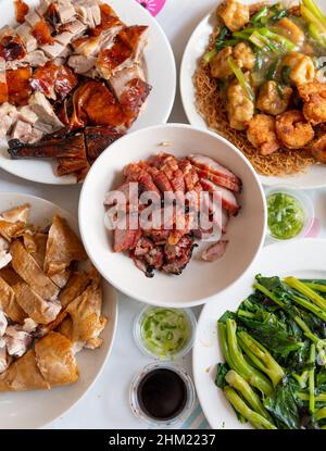 Blick von oben auf einen Esstisch mit einer Auswahl an Fleisch- und Gemüsegerichten für ein Festtagsfest. Stockfoto