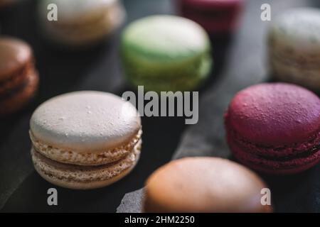 Farbenfrohe französische Macarons im Hintergrund, Nahaufnahme. Verschiedene bunte Makronen in geschmackvoller süßer Farbe - Bakery Concept Image Stockfoto