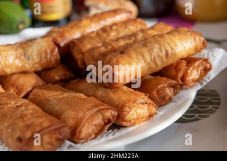 Ein voller Teller mit gebratenen goldenen, knusprigen Frühlingsrollen. Stockfoto