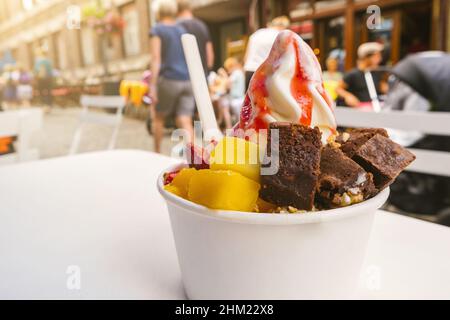 Gefrorener Joghurt mit Brownie- und Obstteller auf einem Tisch Stockfoto