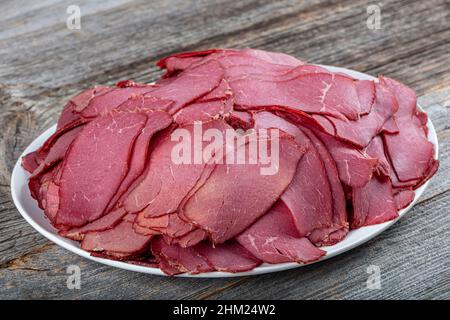 Getrocknetes Beef Jerky vor einem Hintergrund. Hintergrund Textur von mehreren Stücken Rindfleisch ruckartig. Nahaufnahme eines leckeren Jerky-Snacks. Stockfoto