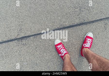 Feet from Above Konzept, Teenage Person in Red Sneakers auf der Straße stehend, Blank Copy Space in Front, Point of View Shot Stockfoto