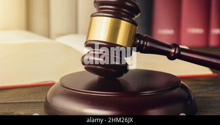 Richter gavel auf einem offenen Gesetz Buch in einem Gerichtssaal Stockfoto