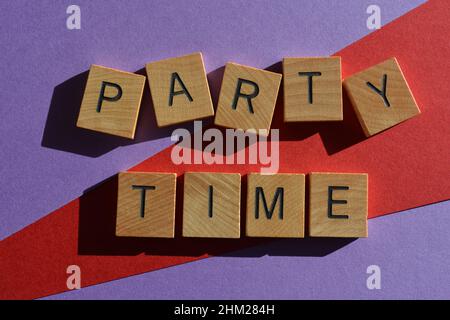 Party Time, Wörter in Holzbuchstaben isoliert auf hellen und bunten Hintergrund Stockfoto