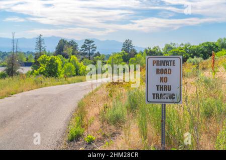 Kleine Straße mit einem Wegweiser von Private Road No Thru Traffic auf der Seite Stockfoto