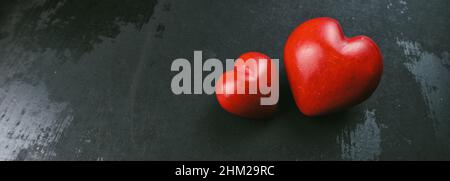 Grußbanner zum Valentinstag. Rotes Herz auf dem schwarzen Grunge-Hintergrund Stockfoto
