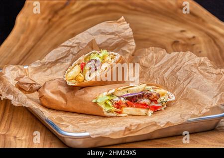 Köstlicher saftiger Shawarma auf einem Holztisch Stockfoto